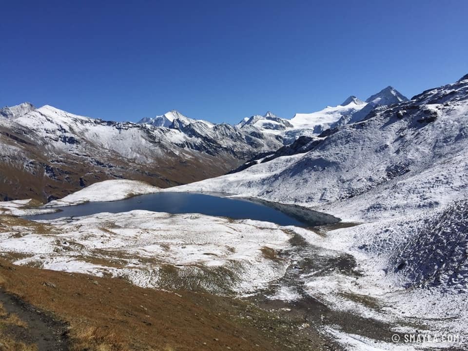 Un lac entre les pentes enneigées